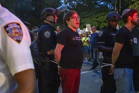 People seen under arrest with hands in disposable zip tie handcuffs are loaded onto NYPD police bus during a rally led by leftist Jewish groups near the Trump Hotel at Columbus Circle to demand an end to the war in Gaza.
