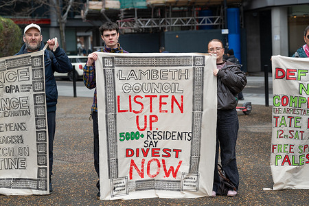Protesters hold a banner written on "Lambeth council listen up. 5000 residents say divest now" during the rally. Pro-Palestine artists and activists gathered outside the Tate Modern during a demonstration calling for a Free Palestine and the protection of freedom of speech in the UK.