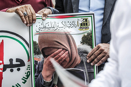 Palestinian men hold a portrait of their imprisoned relative during a solidarity rally In the city of Nablus, north of the occupied West Bank. Palestinians staged a protest to demand a prisoner exchange agreement with the Israeli government and Hamas.
