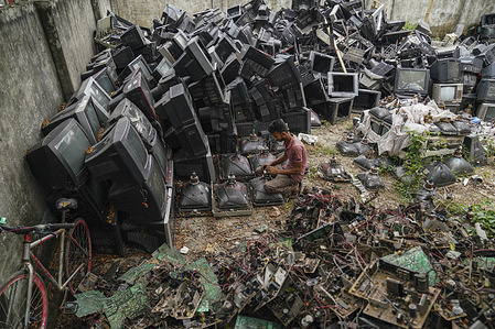 A man is seen working at a TV recycling scrap yard in Dhaka.