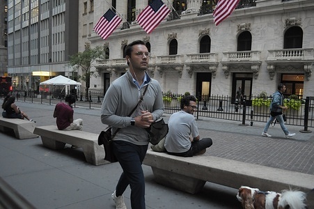 A person walks past the New York Stock Exchange in the Financial District in Manhattan, New York City.