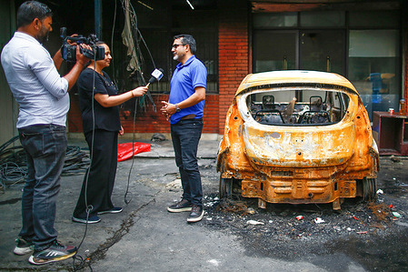 A journalist speaks live in front of his burnt vehicle inside of Kantipur Publications, Nepal’s largest media network during the demonstration. Nepal faces one of its largest youth-led uprisings as Gen Z protests against corruption and government restrictions after a social media ban. At least 72 people have been killed in clashes, prompting curfews and army deployment. Prime Minister KP Sharma Oli has resigned, with Sushila Karki appointed as Nepal’s first female interim prime minister to oversee elections in March 2026.