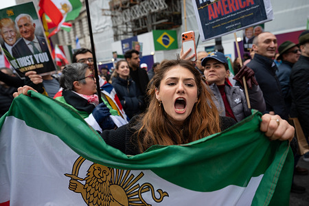 A protester chants slogans while holding a flag of the monarchy of Iran during the rally. Supporters of Iran’s exiled crown prince Reza Pahlavi marched through Westminster during a demonstration calling for the overthrow of the Islamic Republic and the restoration of the monarchy in Iran. Protesters waved pre-1979 Iranian flags and banners backing Donald Trump and calling for American military intervention against the Iranian government.