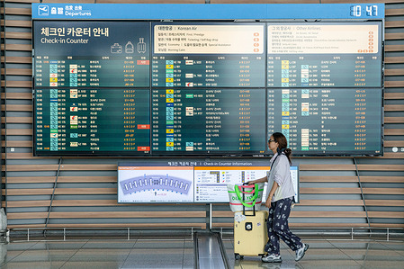 A tourist with baggage walks in front of the Check-In counter billboard at Incheon International Airport. Incheon International Airport was ranked third globally for international passenger traffic in 2024, according to data released in July 2025 by Airports Council International (ACI) World.