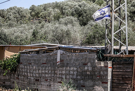 General view of an Israeli flag hanging in a Palestinian neighborhood in the town of Bruqin, west of Nablus, in the northern occupied West Bank. Jewish settlers have launched campaigns to hang Israeli flags in Palestinian towns near Jewish settlements after the Israeli Knesset approved the annexation of the West Bank.