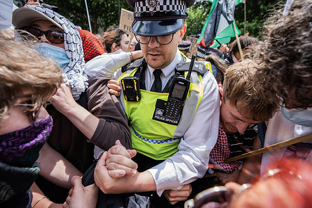 A Policer Officer attempts to arrest a protester during a demonstration. Palestine Action supporters clashed with Police in Trafalgar Square as the government confirms ban and proscribes the action group responsible for attacking 2 RAF planes and multiple Elbit Systems sites in the UK.