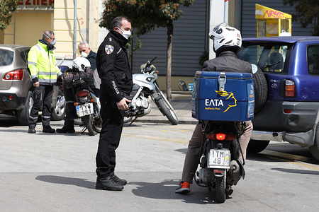 A police officer inspects a motorcyclist during the curfew in Patras.
Greece announced a lock down, restricting movement to combat the spread of Coronavirus.