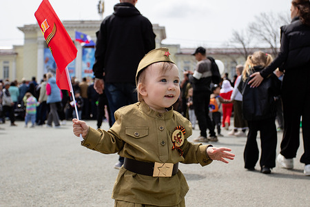 A girl in a uniform similar to the military uniform of the Second World War holds a red flag and St. George's ribbon. Citizens seen with Soviet symbols and emblems seen on May 9 during the Victory Day celebrations.