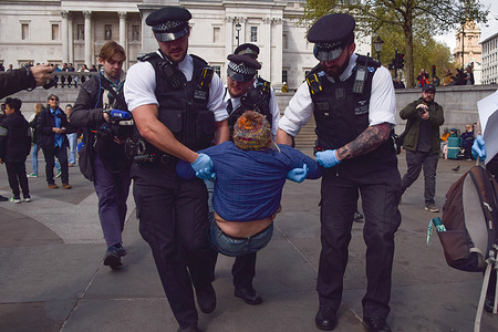 Police officers arrest a protester in Trafalgar Square during a demonstration in support of the activist group Palestine Action, which is still banned under terrorism laws. Hundreds of supporters gathered with placards stating 'I oppose genocide, I support Palestine Action'.