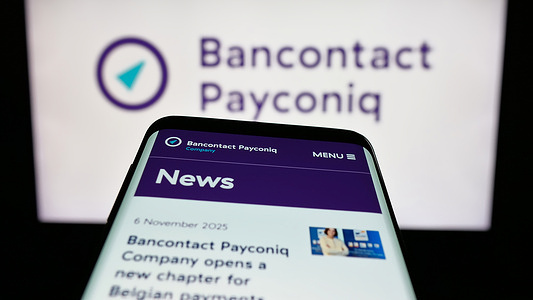In this photo illustration, a mobile phone with the website of Belgian company Bancontact Payconiq Company seen on screen in front of logo.