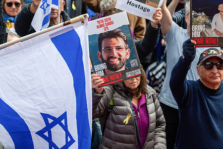 A protester holds a picture of a hostage as pro-Israel groups mark the first anniversary of the October 7th Hamas attack. A pro-Israel rally was held in Melbourne, marking the one-year anniversary of the October 7th attacks. Demonstrators gathered to show support for Israel amidst the ongoing conflict with Hamas, waving Israeli flags and holding banners advocating for Israel's right to defend itself while calling for peace and an end to terrorism. The event drew a significant crowd, with speakers emphasizing international solidarity with Israel and the need for security and stability in the region.