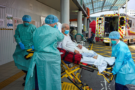 Health workers unload a patient from an ambulance outside the accident and emergency department at Princess Margaret Hospital in Hong Kong. Hong Kong faces its worst Covid -19 coronavirus outbreak, and its hospitals are overwhelmed.