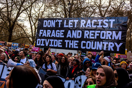 Protestors hold a large banner during the Stand Up To Racism March in London Thousands of people on the streets of London marched against the far right.