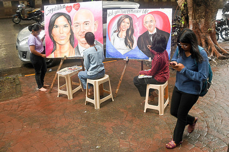 Students from Gurukul school of art paint a poster outside their art school congratulating Jeff Bezos and Lauren Sanchez ahead of their wedding in Venice.
