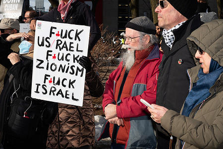 Protesters display signs with political messages Hundreds gathered across from the U.S. Consulate in Toronto on Saturday, hours after reported U.S. and Israeli strikes on Tehran, as sharp divisions within the Iranian diaspora played out in public. Some demonstrators voiced hope that military pressure could weaken Iran’s clerical leadership, while others warned that foreign intervention risks civilian casualties and wider regional war. The rally underscored the fraught debate over whether external force advances democratic change or deepens instability.
