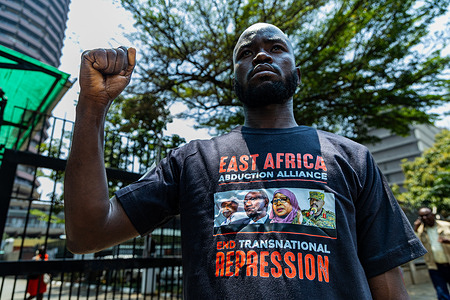 A Kenyan human rights activist holds up his fist during a demonstration outside the Ministry of Foreign Affairs, calling for the release of political prisoners. The activists called for the resignation of Kenya's foreign minister and senior police officials over their alleged involvement in the abduction of Ugandan opposition leader and former presidential candidate Kizza Besigye in Nairobi in late 2024. Besigye was forcibly returned to Uganda, where he faced charges before a military court in Kampala, according to Amnesty International.