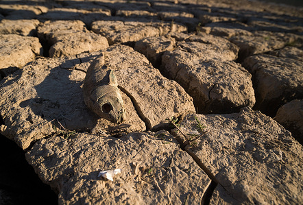 A dead fish is seen over the cracked ground of the La Vinuela reservoir before a protest against climate change, organized by Amnesty International. To mark International Water Day, activists from Amnesty International, along with several environmental organizations, have denounced climate change and its effects on human rights around the world through a performance that represents the symbolic death of the La Viñuela reservoir. The Viñuela reservoir, which supplies water to the municipalities near the Axarquia region, is at minimum water levels due to the severe drought in the province.