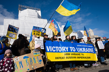 Protesters in solidarity with Ukraine reach Trafalgar Square with placards, flags and banner for the demonstration. Following the first anniversary of Russia-Ukraine War, protest groups gathered in Central London and marched to Trafalgar Square, calling for peace in Ukraine and Iran.
