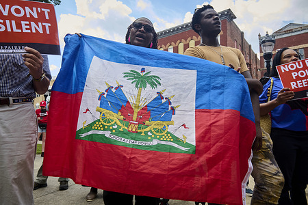 A woman seen holding a flag during the protest against the ending of temporary protected visa status. The Trump administration's hardline anti-immigration policies saw the revocation of temporary protected visas status for refugees from Haiti, forcing many migrants with years in local communities to suddenly return to the troubled island nation that the US State Department has advised against traveling to due to life-threatening political turmoil and weather-related disasters.