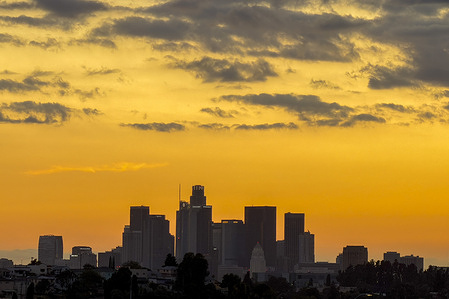 Storm clouds blanket the downtown Los Angeles skyline during the sunset Thursday,