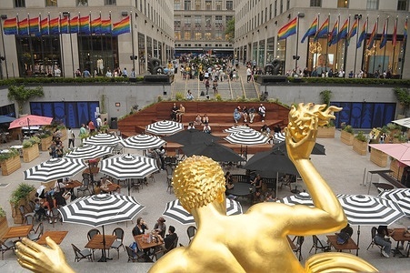People are seen in front of the Prometheus sculpture in Rockefeller Center, Manhattan, New York City.