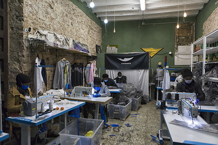 Members of the Sindicato de Manteros make gowns for medical staff.
In the heart of the Raval district, street vendors of Barcelona, known as Sindicato de Manteros, turn their clothing store into a workshop of masks and medical gowns for health care staff to fight against the Coronavirus (Covid-19) pandemic. The Sindicato de Manteros was born in 2015, when street vendors in Barcelona organised themselves to defend their rights.