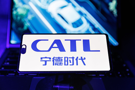 In this photo illustration, a CATL logo is displayed on a mobile phone in front of its website on a computer screen. CATL, the world’s largest EV battery maker, plans to launch a Hong Kong IPO in the week of May 12, 2025, aiming to raise at least $5 billion. It will be the city's biggest IPO since Kuaishou in 2021. Shares will be priced 10% below its Shenzhen listing.