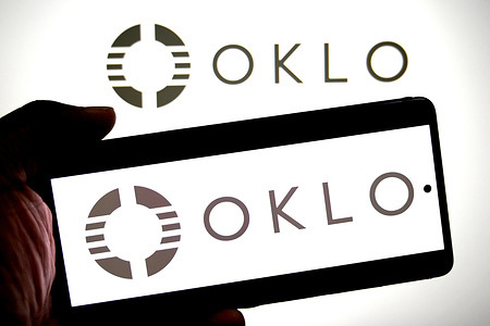 In this photo illustration,an OKLO logo is seen displayed on a smartphone and in the background.