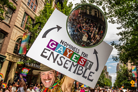 A participant at the Pride parade creatively reflects the crowd in a mirror, playfully declaring them nominees for the 'gayest ensemble. Thousands wearing the vibrant rainbow colors gathered to celebrate and show support for the LGBTQ+ community during the Pride parade.