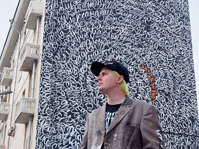 The artist seen close to his piece.
The famous Russian artist-calligrapher Pokras Lampas together with the search and rescue team "LizaAlert" created an impressive art object dedicated to the International Day of Missing Children.
Over the 10 years of "LizaAlert" team's existence it has received 22,000 search requests of missing children. The names of the last 400 children on this list were placed on the wall of a house in the centre of Moscow.
