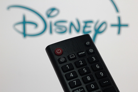 In this photo illustration, a close-up of the remote control and the Disney Plus logo on the TV screen.