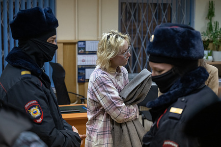 The vocalist of the band Stoptime, Diana Loginova, who has twice served 13 days of arrest for organizing gatherings and disturbing public order due to street concerts, is about to leave the courtroom escorted by the police. Diana Loginova and Alexandros Orlov were sentenced to 13 days of arrest for organizing a mass gathering linked to a street concert by the band Stoptime. The Russian authorities continue to persecute members of the group for performing anti-war songs by artists labeled as “foreign agents.”
