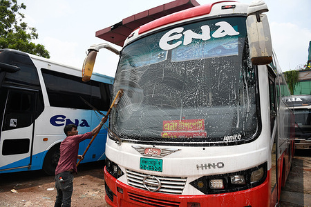 A worker cleans a bus as public transport resumes after a period of lockdown at the Gabtoli bus terminal in Dhaka.
After a lockdown, public transport is reopening starting tomorrow all over the country in Bangladesh.
