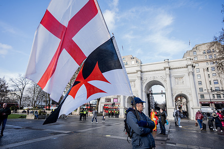UKIP supporters carrying Christian flags await the start of UKIP's march with Jesus from Marble Arch, London. UKIP supporters went on a “March With Jesus” through Central London to Trafalgar Square holding aloft Christian crosses. UKIP leader Nick Tenconi led the purported ‘religious procession’ reciting prayers and reading from the Bible along the way.