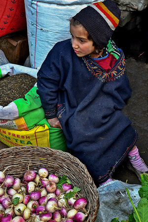A young girl seen waiting for customers as she sells vegetables during a cold winter day in Srinagar, Kashmir. 
Kashmir is the northernmost geographical region of the Indian subcontinent. It is currently a disputed territory, administered by three countries: India, Pakistan and China.