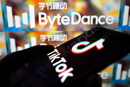 In this photo illustration a TikTok logo is seen displayed on a smartphone with a ByteDance logo on the background.