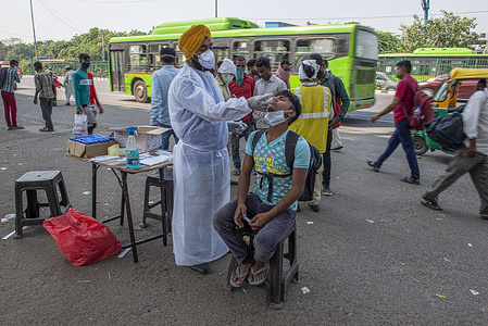 A health worker wearing personal protective equipment gear (PPE) takes a swab sample from a man for a Covid-19 test during a random test drive for travelers near Delhi Uttar Pradesh Border at Anand Vihar Bus Terminal.
Delhi Government takes precautionary health measures against Covid-19 as people travel during the festival season.