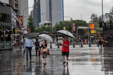 Pedestrians shelter from the rain beneath an umbrella on a rainy day in Brisbane.
Severe storm hits South East Queensland and Brisbane CBD causing traffic chaos and floods.