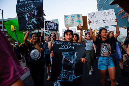 Protesters march with placards expressing their opinion after sunset during Scotus protest. Protestors gather after SCOTUS over turned Roe v. Wade. Hundreds of protesters took to the street to protest against he Court's decision in the Dobbs v Jackson Women's Health case overturns the landmark 50-year-old Roe v Wade case, removing a federal right to an abortion.