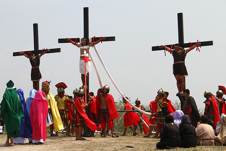 Fifty-eight year old Ruben Enaje on the cross for the 32nd year. Good Friday crucifixion rights were held in Cutud, Pampanga during the annual Maleldo Holy Week celebration.