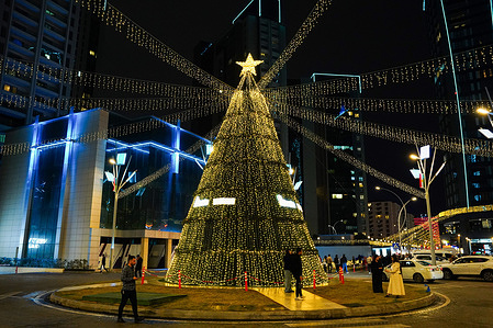 People seen walking near a Christmas tree at Empire Complex in preparations of Christmas and New Year celebrations. Year celebrations in the town of Ankawa, Erbil, the capital of the Kurdistan Region of Iraq.
