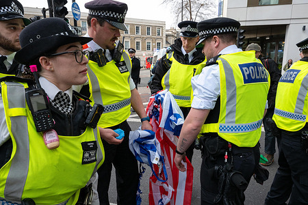 Police officers hold the burned remains of a US and Israel flag during the rally. Protesters gathered outside the United States Embassy in Nine Elms for a demonstration against US and Israeli military actions in the Middle East, including the ongoing war involving Iran and continued conflict in Gaza. The march, organized by pro-Palestinian and anti-war groups, moved towards Victoria, with participants walking in the road and being challenged by police along the route. Demonstrators carried flags and placards and chanted slogans opposing Western intervention, expressing solidarity with countries including Lebanon, Yemen, Cuba and Venezuela. At the end of the march, protesters set fire to US and UAE flags as tensions surrounding the demonstration escalated.