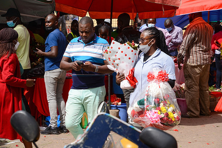 A woman in the company of a male guy is seen carrying flowers during Valentine's Day in downtown, Nairobi.