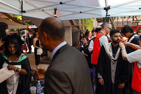 Event staff are seen assisting a student with wearing a gown. The pre-graduation event brings together Royal Melbourne Institute of Technology (RMIT) students, including many overseas students studying in Australia. International education is a key part of Australia’s higher-education sector and attracts students from around the world.