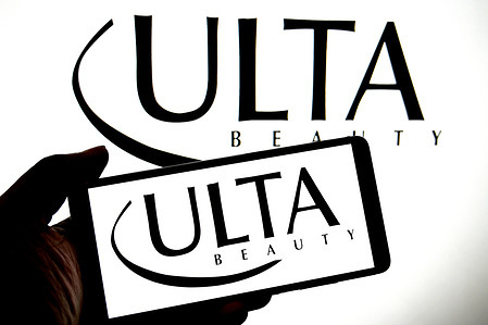 In this photo illustration, an Ulta beauty logo is seen displayed on a smartphone and in the background.