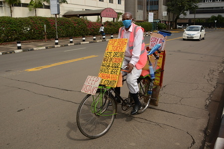 A man raising awareness about corona virus rides his bicycle wearing a face mask as a preventive measure in Nairobi during the pandemic. 
Kenya on April 7, 2020 confirmed 14 more cases of Coronavirus, bringing the total number of those affected to 172.