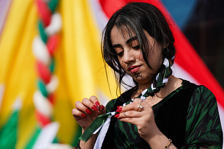 A Kurdish woman braids her hair during a demonstration in solidarity with Kurdish female fighters in Rojava. Women in Iraqi Kurdistan and abroad have taken to the streets and social media to braid their hair in solidarity after a Syrian soldier appeared in a video boasting of cutting the braid of a Kurdish fighter in Raqqa.