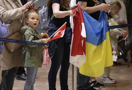 A young supporter greets the 300 Ukrainian refugees who arrive at the James Richardson International airport in Winnipeg, Manitoba.
