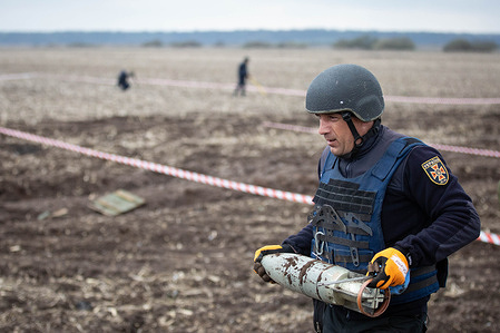 A Ukrainian sapper carries a bomb at the site of recent fighting between the Russian and Ukrainian armies near the town of Brovary in the Kyiv region.