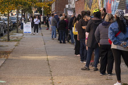 People seen standing in a long line wrap around the block to cast their vote at Variety Boys & Girls Club during early voting for the U.S. Presidential election in the Astoria neighborhood of Queens borough in New York City.